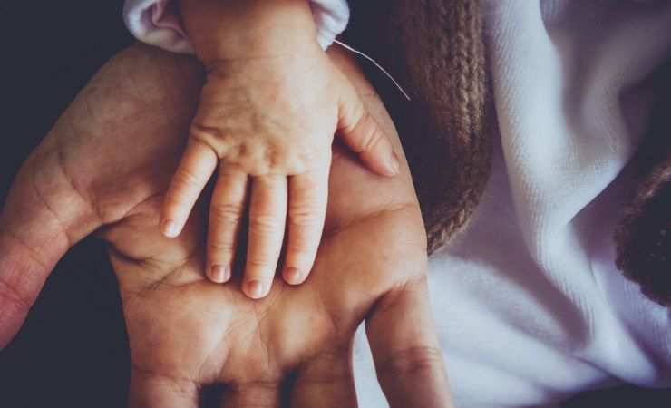 mano di un bambino su una mano di un adulto