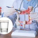 medico fa vedere l'intestino e nel cerchietto un bicchiere