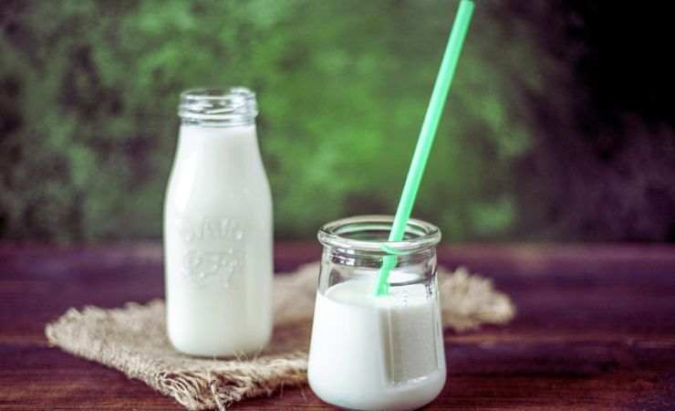 latte in una bottiglietta e in un bicchiere con la cannuccia