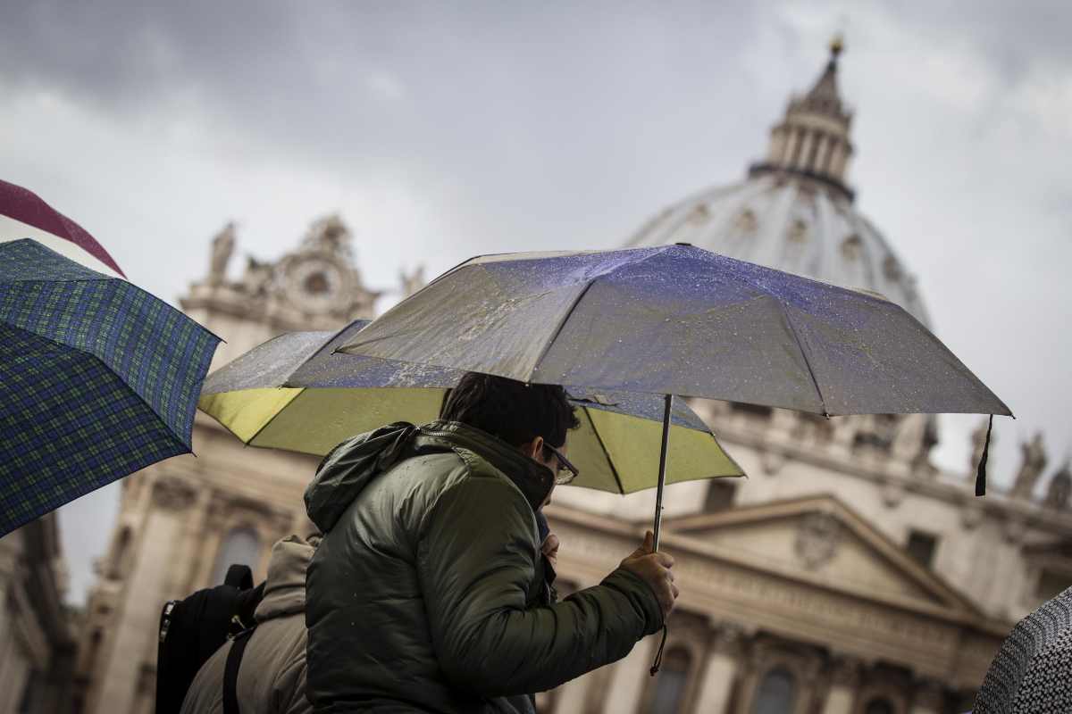 persone si riparano dalla pioggia con l'ombrello
